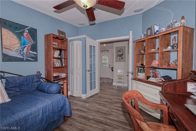 bedroom with a textured ceiling, ceiling fan, and hardwood / wood-style flooring