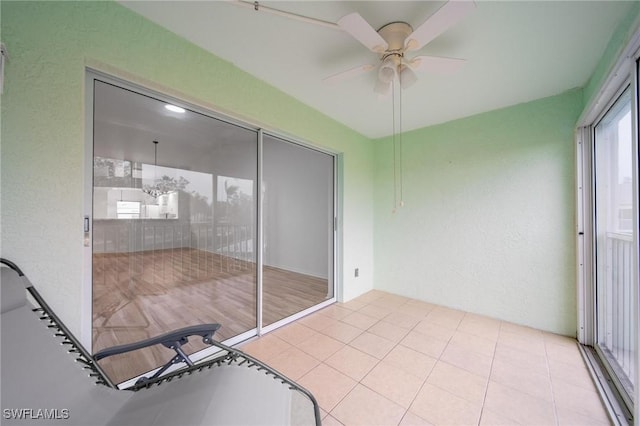 unfurnished sunroom featuring ceiling fan