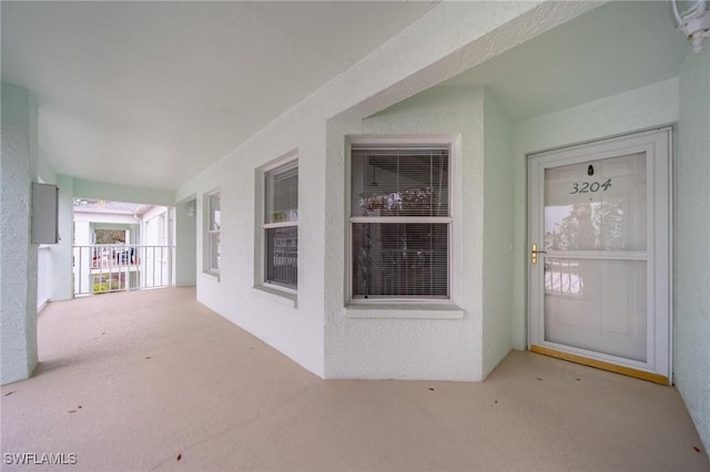 view of exterior entry with a porch and stucco siding