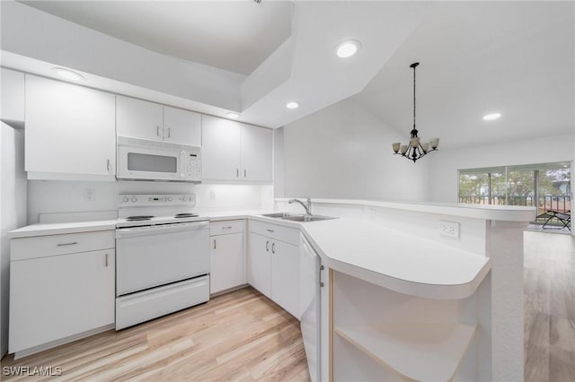 kitchen featuring a peninsula, white appliances, a sink, and light countertops