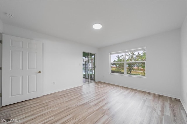 empty room featuring light wood finished floors and baseboards