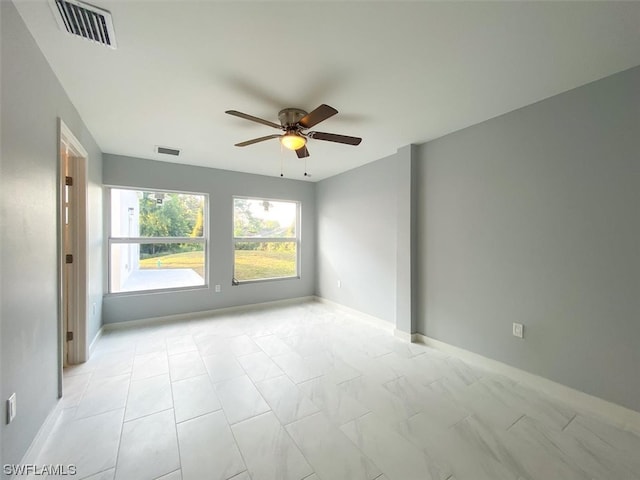 tiled spare room with ceiling fan