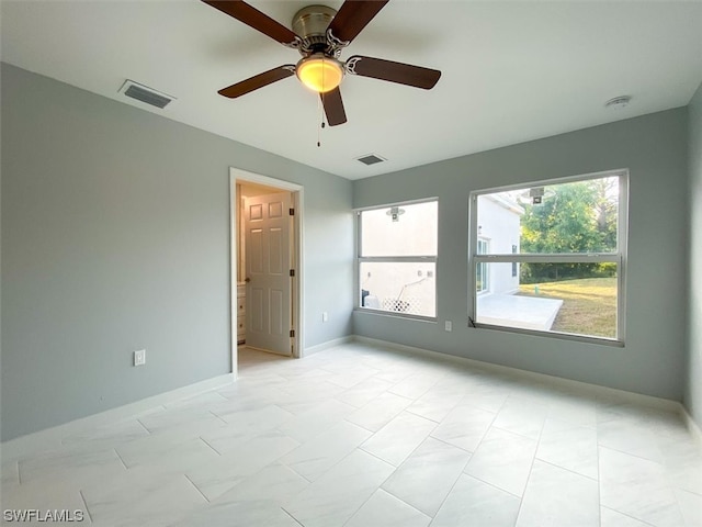 tiled spare room with ceiling fan