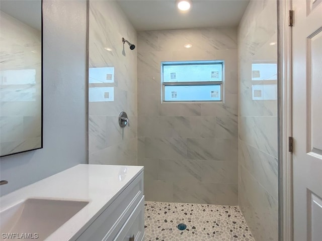 bathroom featuring a tile shower and vanity