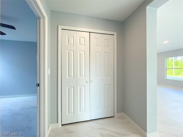 interior space with a closet, ceiling fan, and light tile floors