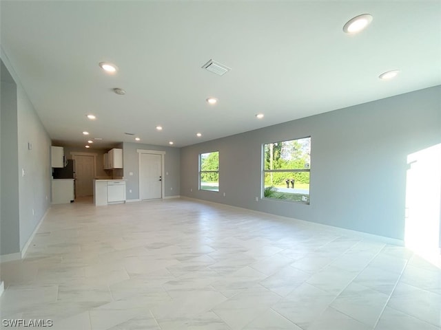 unfurnished living room featuring light tile flooring