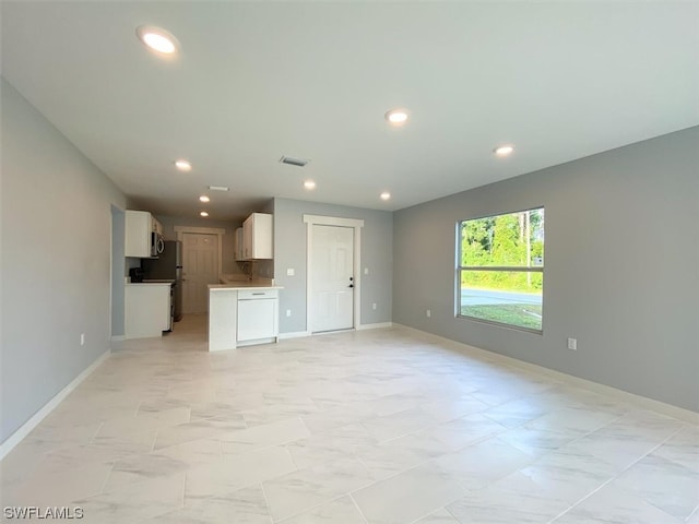 unfurnished living room featuring light tile floors