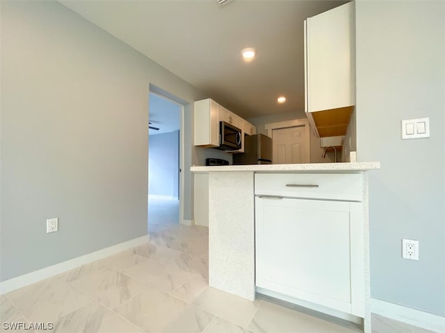 kitchen featuring kitchen peninsula, ceiling fan, white cabinets, and light tile floors