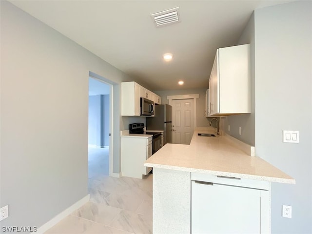 kitchen featuring white cabinets, appliances with stainless steel finishes, light tile floors, and sink