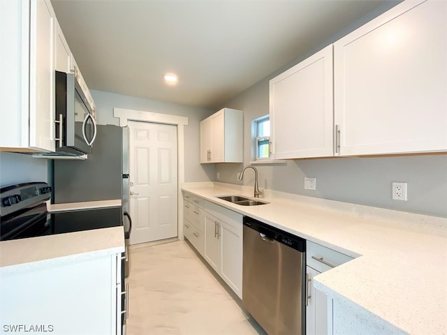 kitchen featuring light tile flooring, white cabinets, appliances with stainless steel finishes, and sink