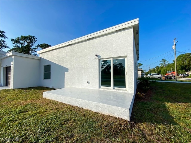 back of house with a lawn and a patio area