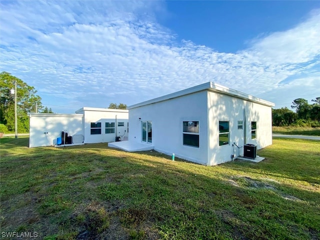 rear view of property with a yard and central AC unit