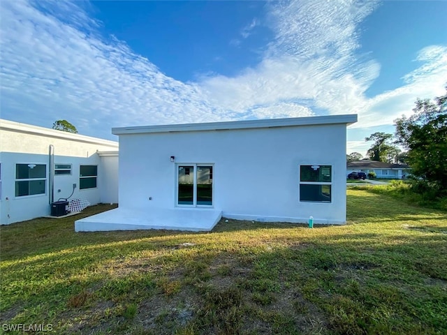 rear view of house featuring a yard, central air condition unit, and a patio