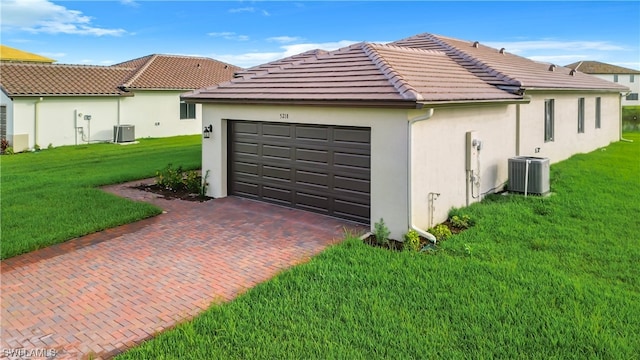 garage with a yard and central air condition unit