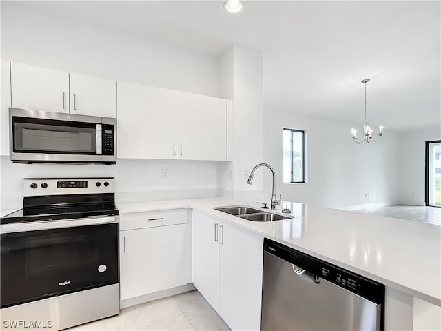 kitchen with stainless steel appliances, a notable chandelier, white cabinetry, and sink