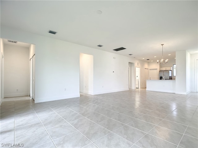 unfurnished living room featuring light tile flooring and a chandelier