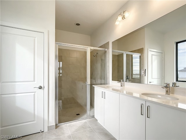 bathroom featuring tile floors, a shower with door, double sink, and oversized vanity