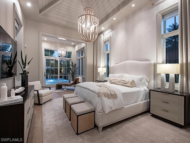 bedroom featuring beam ceiling, multiple windows, light wood-type flooring, and an inviting chandelier