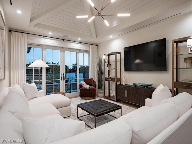 living room with french doors, a water view, a chandelier, and beamed ceiling