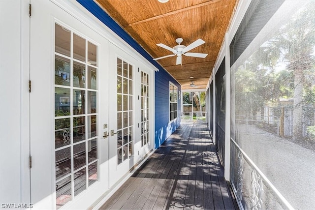 unfurnished sunroom featuring wood ceiling, ceiling fan, and french doors