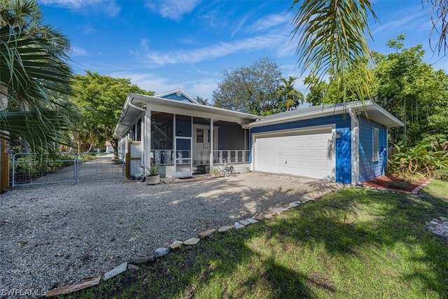 view of front of property featuring a garage and a sunroom