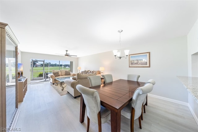 dining space with light wood-type flooring and ceiling fan with notable chandelier