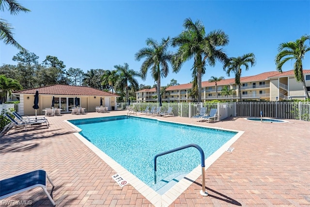 view of swimming pool featuring a community hot tub and a patio