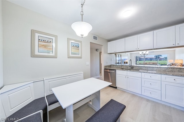 kitchen featuring white cabinets, dishwasher, and light wood-type flooring