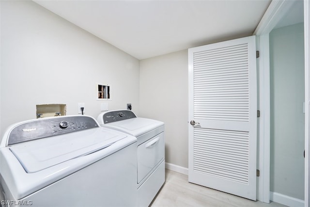 clothes washing area with washer hookup, electric dryer hookup, independent washer and dryer, and light wood-type flooring