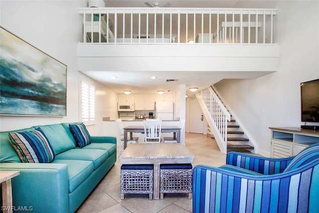 tiled living room featuring a towering ceiling