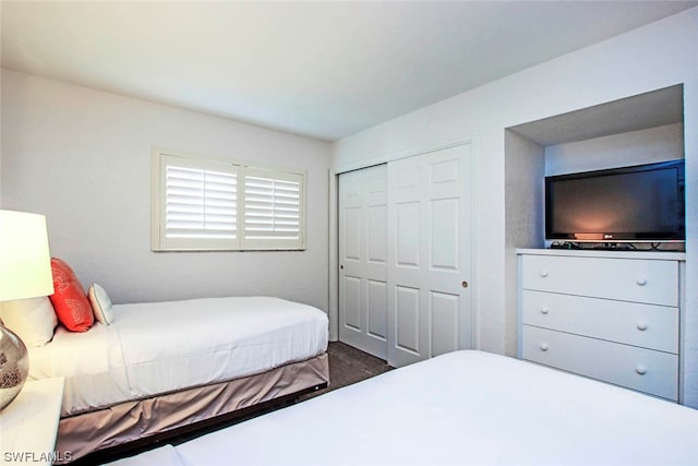 bedroom with a closet and dark hardwood / wood-style floors