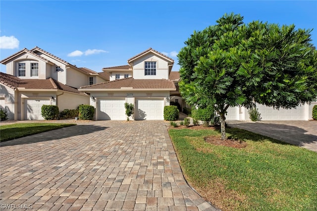 mediterranean / spanish-style home featuring a garage and a front yard