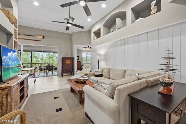 living room with a high ceiling, ceiling fan, and light tile patterned flooring