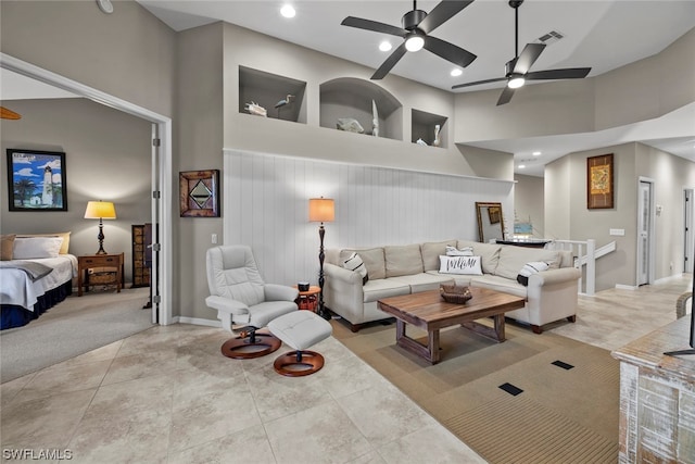 living room featuring a towering ceiling, ceiling fan, and light tile patterned floors