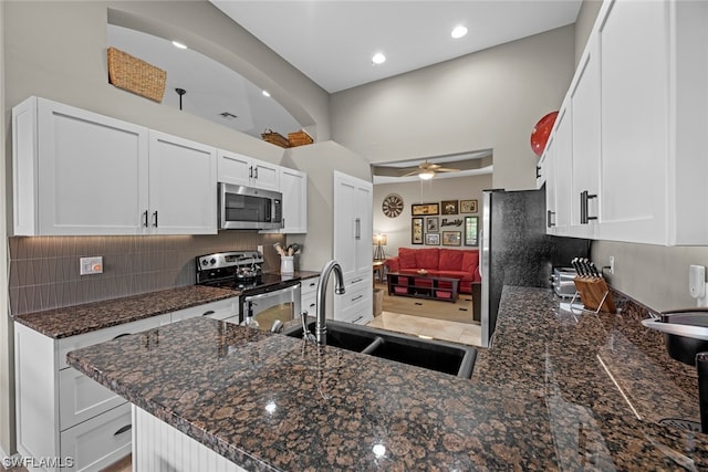 kitchen with white cabinets, sink, kitchen peninsula, and appliances with stainless steel finishes