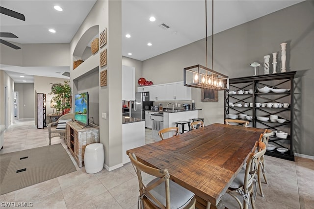 dining area featuring ceiling fan with notable chandelier, light tile patterned floors, and sink