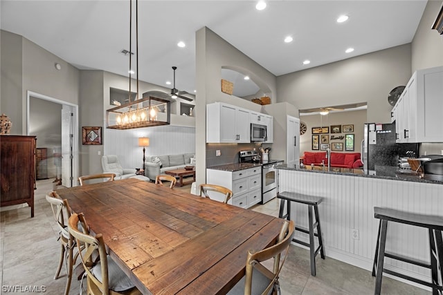 dining area with a high ceiling and ceiling fan