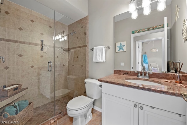 bathroom with toilet, vanity, tile patterned flooring, and a shower with door