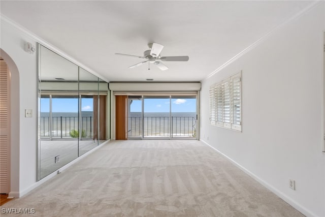 carpeted spare room with crown molding and ceiling fan