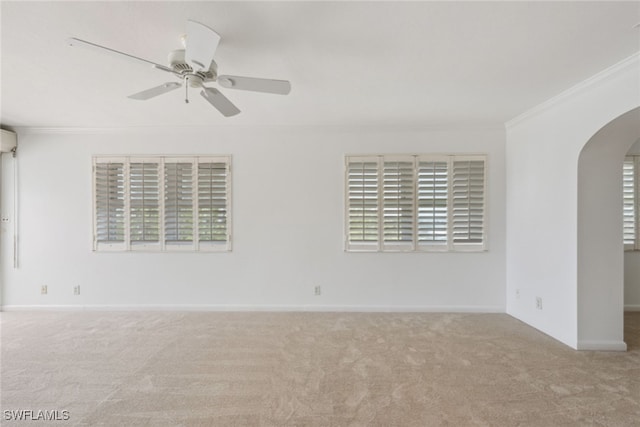 empty room with ceiling fan, light colored carpet, and ornamental molding