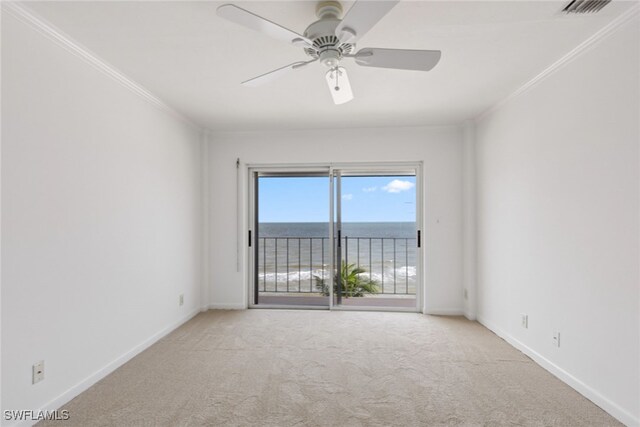 carpeted spare room featuring ceiling fan, ornamental molding, and a water view