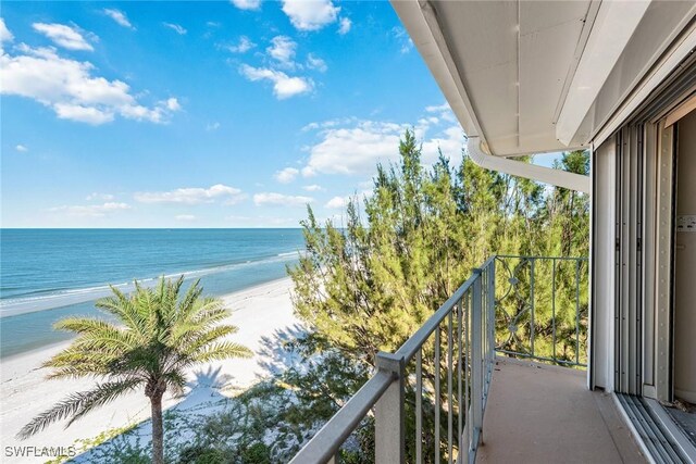 balcony with a water view and a view of the beach