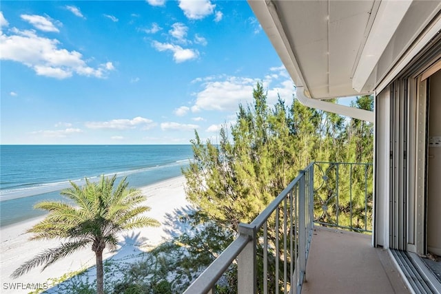 balcony with a water view and a view of the beach