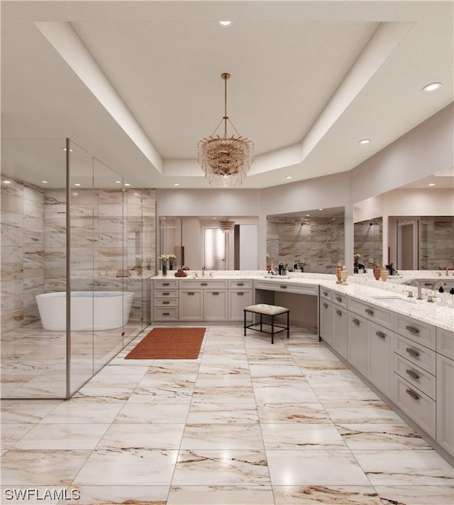 bathroom featuring double sink vanity, a bath to relax in, a tray ceiling, tile flooring, and an inviting chandelier