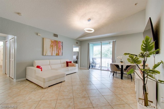 tiled living room with a textured ceiling and lofted ceiling