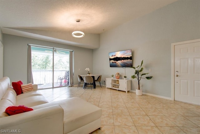 living room with vaulted ceiling, light tile floors, and a textured ceiling