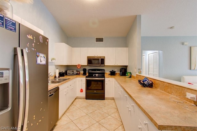 kitchen featuring light tile floors, white cabinetry, sink, and stainless steel appliances