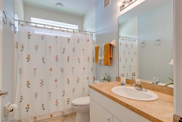 bathroom featuring tile floors, large vanity, and toilet