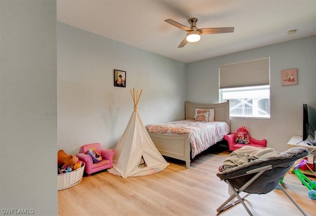 bedroom with light hardwood / wood-style floors and ceiling fan