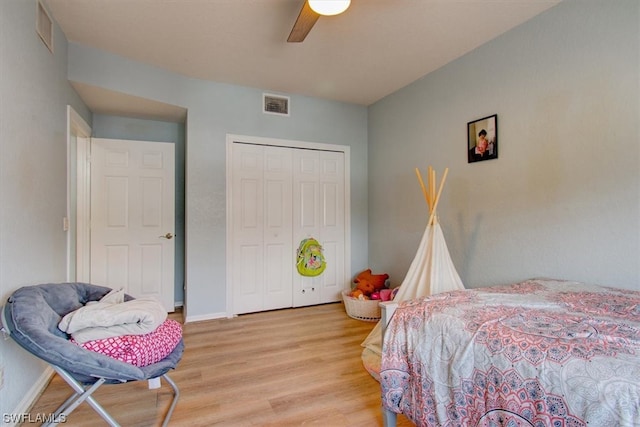 bedroom with a closet, light hardwood / wood-style floors, and ceiling fan